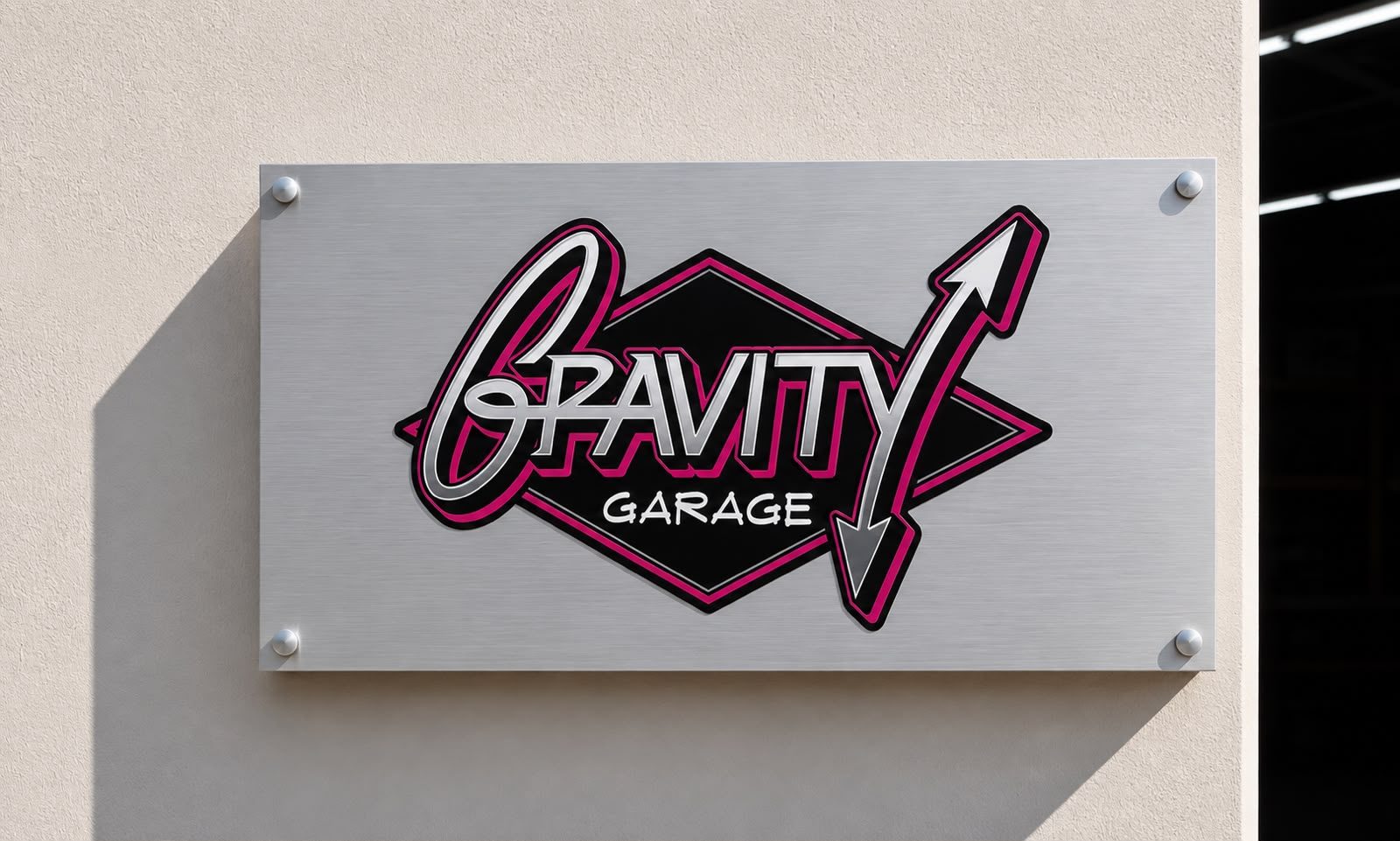 The Gravity Garage sign on a brushed metal plate mounted on the exterior wall beside the unit entrance.