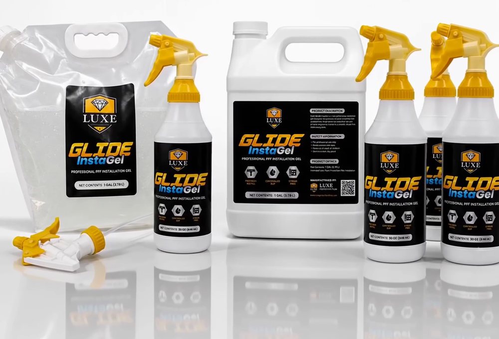The full LUXE Glide InstaGel range: a 64 oz refill pouch, 32 oz trigger-spray bottles, a one-gallon jug, and spare trigger heads.